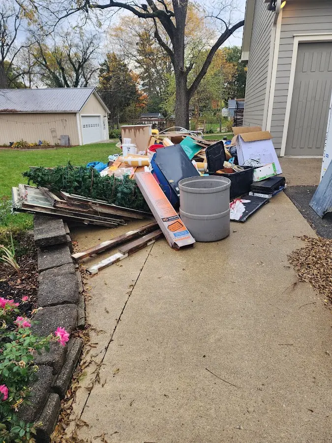 Dumpster being loaded with debris for 12 Yard Dumpster Rental in Madison